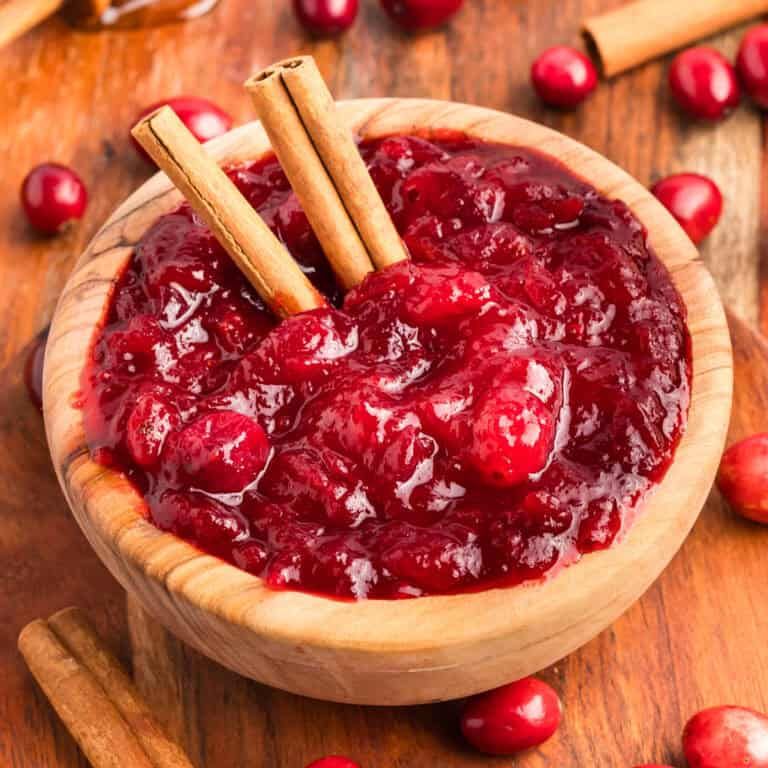 Sweet and tangy cranberry sauce with a hint of cinnamon served in a glass bowl with a spoon